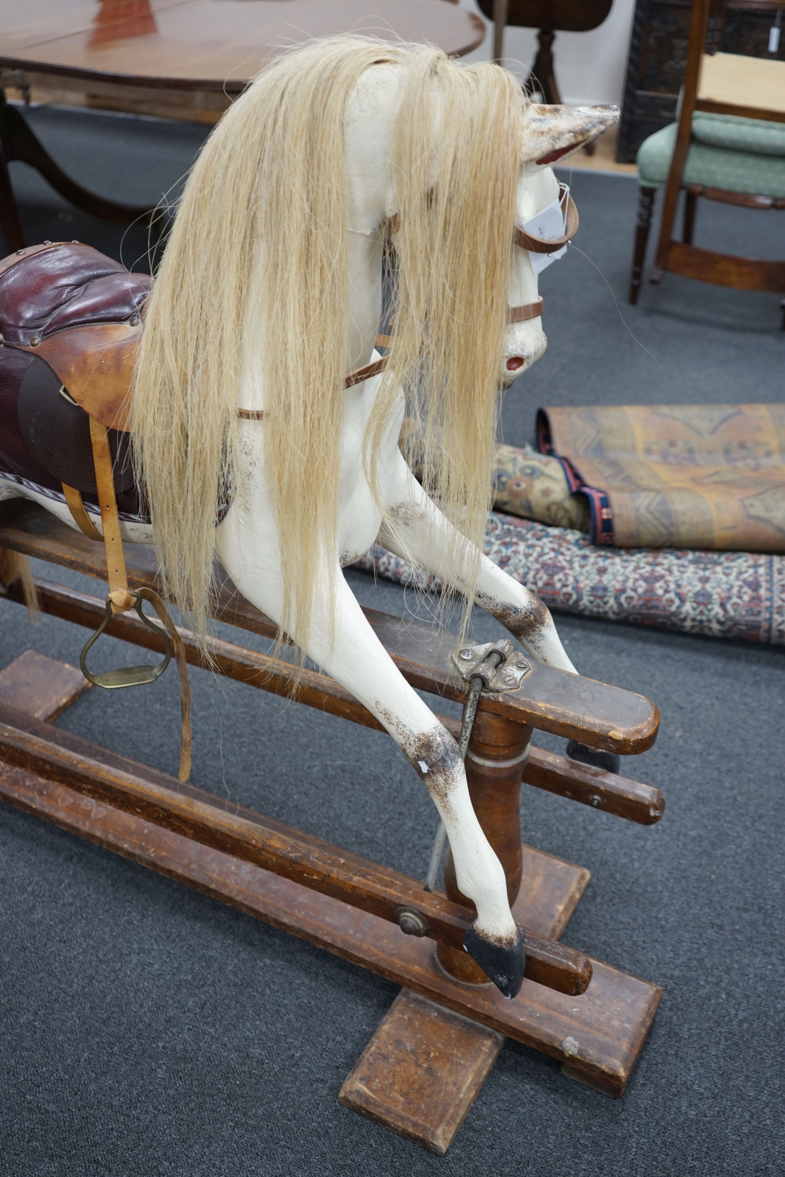 An early 20th century Ayres type dapple grey rocking horse on pine safety frame, width 130cm, height 110cm